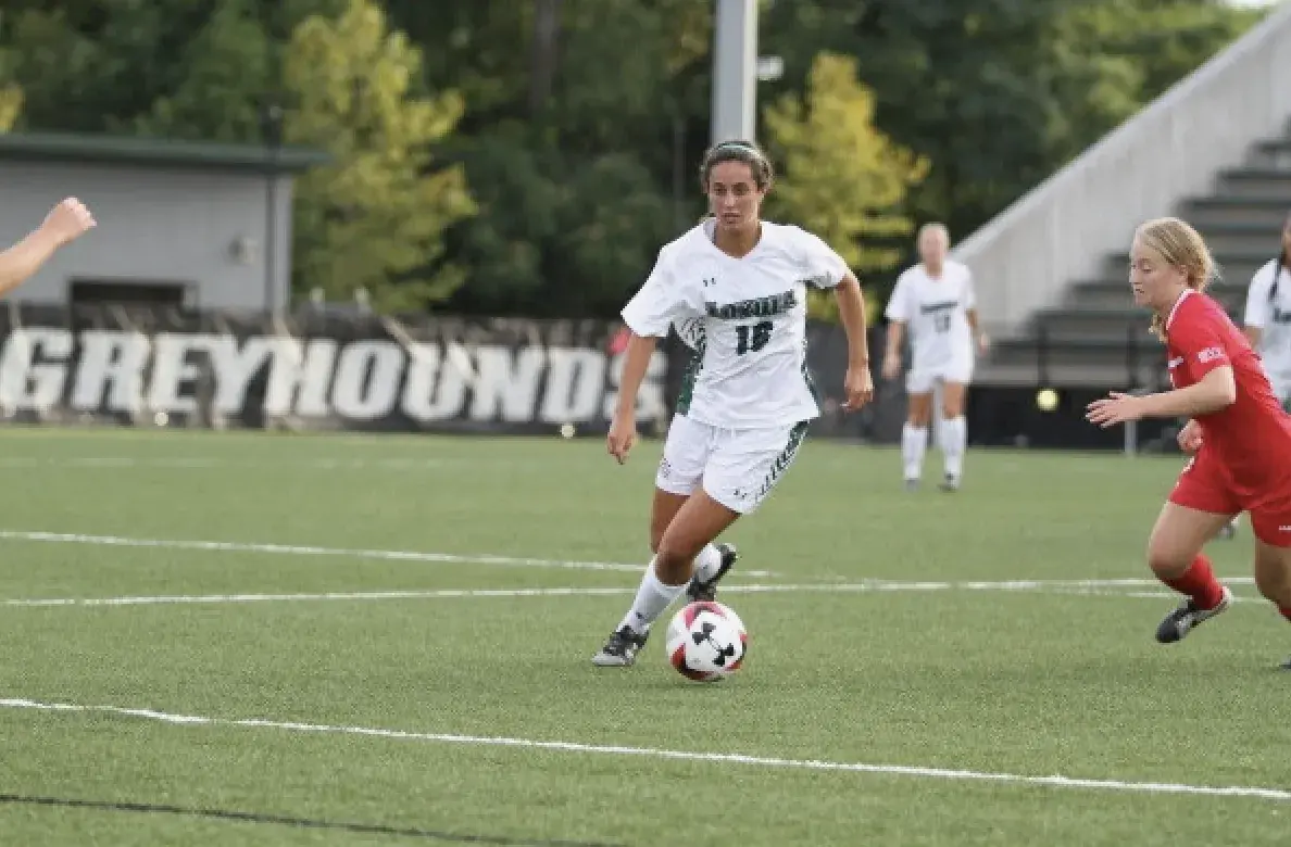 Mia Sardella carrying the ball past a defender at Loyola Maryland's home ground.