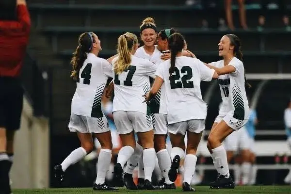 Mia Sardella celebrating a goal with teammates.